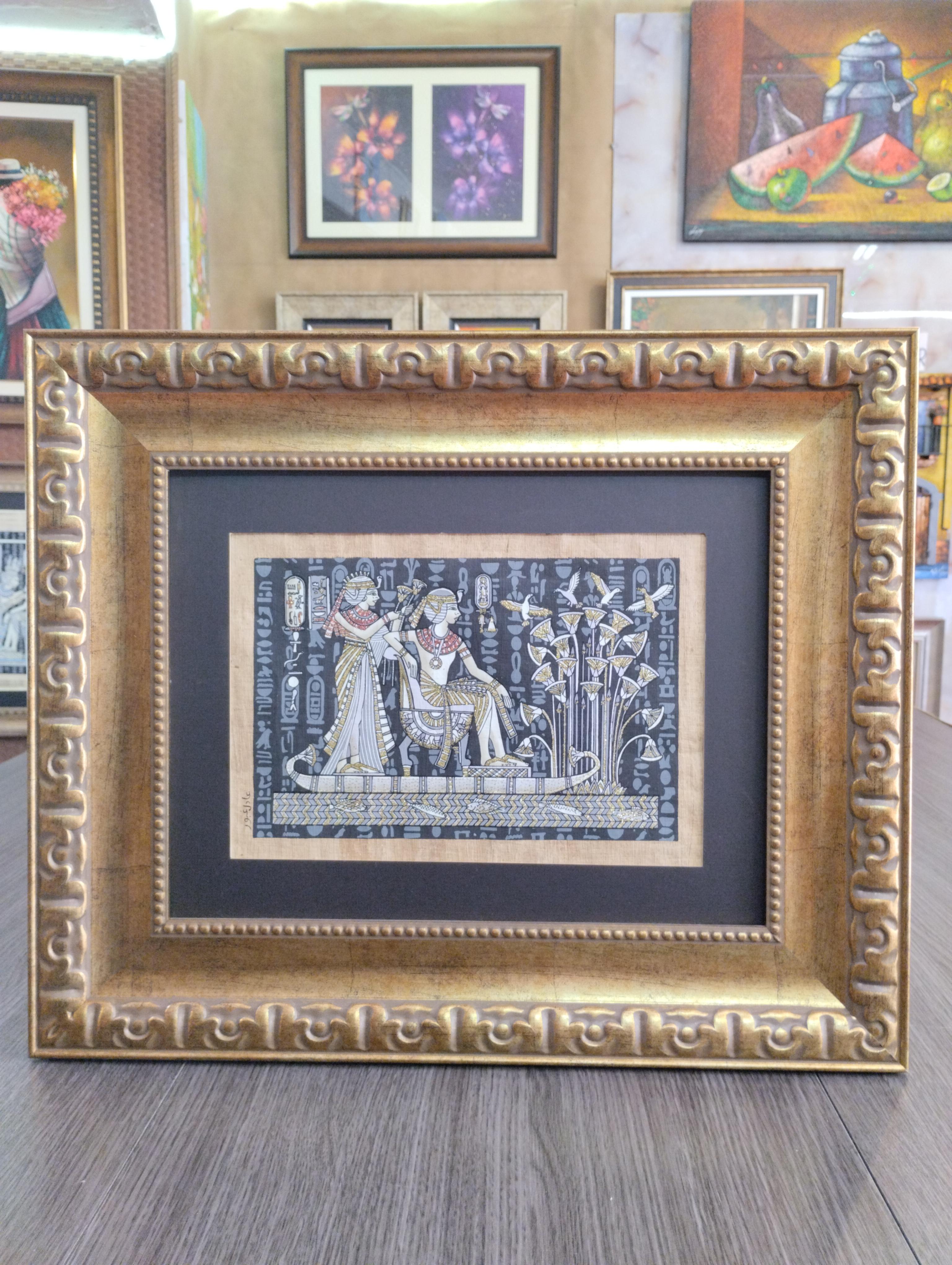 Papiro Reina del Nilo entre Jeroglificos. Escena egipcia con figuras estilizadas y jeroglificos en tonos dorados y negros, rodeada por un marco grueso dorado con relieves decorativos clasicos.