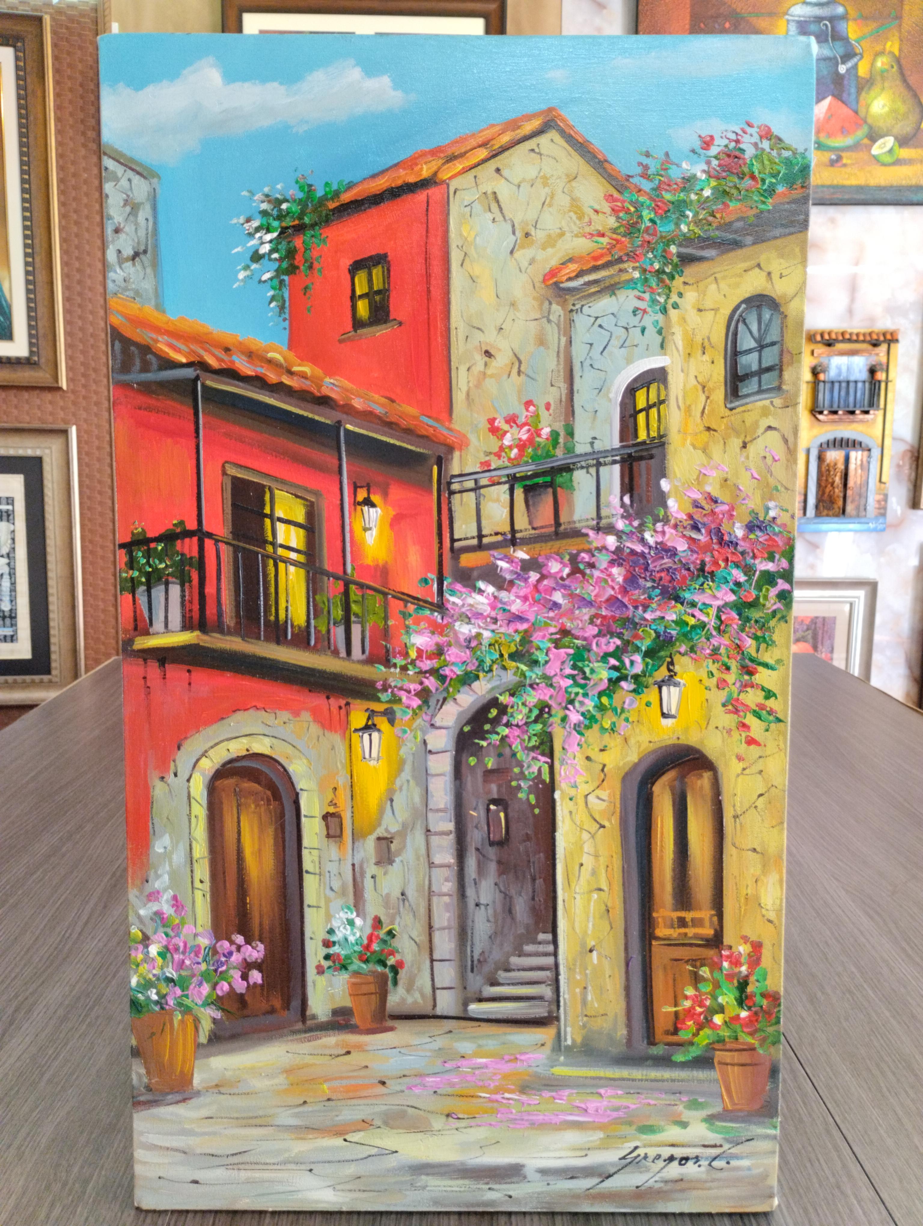 Rincon florido al atardecer. Fachadas coloridas de casas con balcones, flores rosadas y luz calida; puertas de madera y cielo azul, lienzo sin marco con bordes pintados.